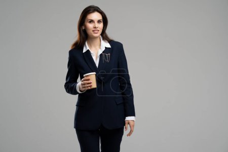 Photo for Photo of charming young businesswoman leader brown hair wear elegant premium formal suit drinking takeout coffee. Lady hold fresh energy espresso. High quality photo - Royalty Free Image