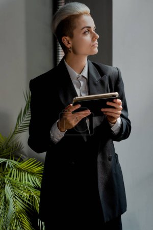 Photo for Confident woman manager holding touch pad and thinking about her tasks. Businesswoman team lead using tablet to notice information. Thoughtful lady in formal suit hold digital device. High quality - Royalty Free Image