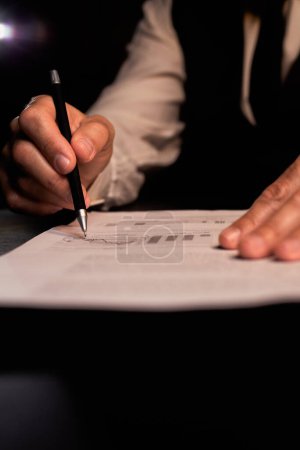 Photo for Analyzing financial plan. Business planning. Businessman write trend line diagram. Night time paperwork. Man holding check his profit graphic. Doing finances and calculations. High quality photo - Royalty Free Image