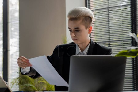 Photo for Important papers. Young blonde businesswoman reading contract. Serious woman reviewing sales reports. Hr manager girl holding documents about candidates. Lady prepared copy of her resume. High quality - Royalty Free Image