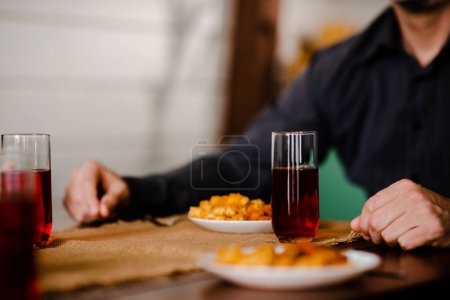 Photo for Close up shot of adult man eating italian macaroni with sauce on kitchen table. Christian male thanksgiving before have lunch alone. Christmas family dining. High quality photo - Royalty Free Image