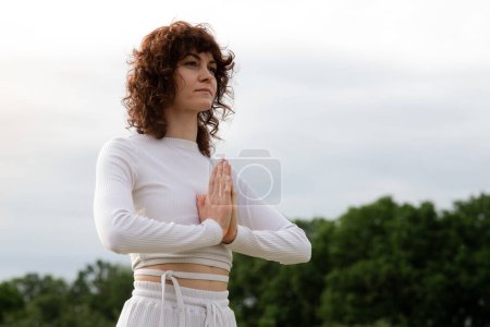 Mädchen meditieren in Gebetsposition. Sportlerin atmet langsam für Chakra-Gleichgewicht. Lady faltete Handflächen zusammen, um sich zu entspannen. Die Frau schloss die Augen und konzentrierte sich auf Yoga. Hochwertiges Foto
