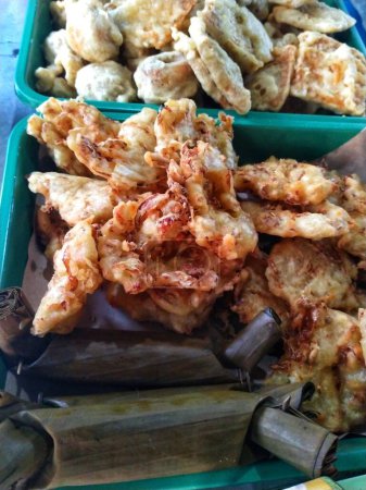 Traditional Indonesian snack Fried Bakwan made from wheat flour dough mixed with a little vegetables and savory spices. Sometimes eaten with lontong, which is rice cooked in rolled banana leaves.