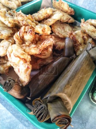 Traditional Indonesian snack Fried Bakwan made from wheat flour dough mixed with a little vegetables and savory spices. Sometimes eaten with lontong, which is rice cooked in rolled banana leaves.