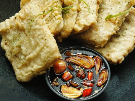 Traditional Indonesian snack, tempe mendoan made from soybeans with savory taste. Usually served fried in wheat flour and eaten with sweet soy sauce, sliced onions and chilies.