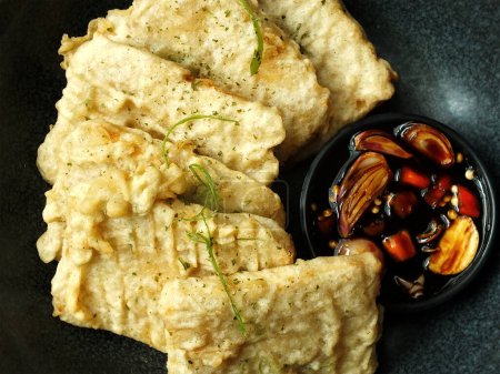 Traditioneller indonesischer Snack, tempe mendoan aus Sojabohnen mit herzhaftem Geschmack. Normalerweise in Weizenmehl gebraten und mit süßer Sojasauce, in Scheiben geschnittenen Zwiebeln und Chili gegessen.