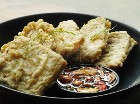 Collation traditionnelle indonésienne, tempe mendoan à base de soja au goût salé. Habituellement servi frit dans de la farine de blé et mangé avec de la sauce soja sucrée, des oignons tranchés et des piments.