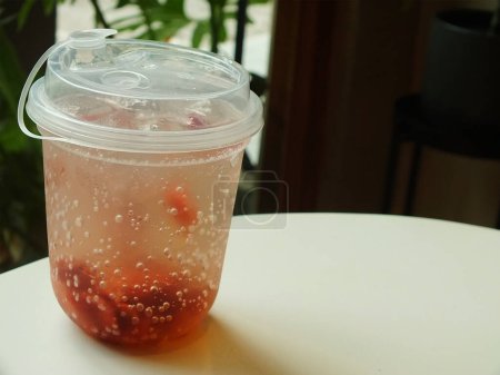 soda aux fraises fraîches et froides avec glace isolée sur un café intérieur flou. boisson fraîche pour la journée d'été. Image de l'alimentation et des boissons pour le café et la restauration