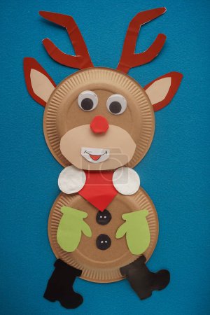 Foto de Christmas New Year Santa's deer handmade. Step by step photo instruction. DIY concept. Step 13-13. Finish. Cut out the black boots and glue them at the bottom. Cute deer is ready. Top view, Flat lay - Imagen libre de derechos