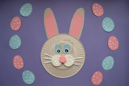 Foto de How to make paper bunny for Easter greetings. Children art project. Step by step photo instruction. DIY concept. Very Peri background color. Step 6. Decorate the eggs with paper sequins. Final - Imagen libre de derechos