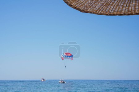 Photo for Parasailing on a parachute against blue sky. Background vacation, photo for postcards, tourist and travel guide. Concept of summer holidays, vacation, tourism. View from under umbrella. Soft focus. - Royalty Free Image