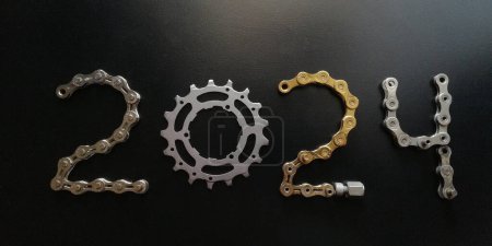 Photo for 2024 Cycles concept background with gold chain and bike part on black background - Royalty Free Image