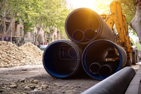 Photo for Large plastic corrugated pipes for water supply lie on the street in the city. The work of utilities to improve the infrastructure of the metropolis. - Royalty Free Image