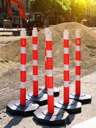 Foto de Foto vertical: postes de plástico restrictivos para controlar el tráfico en la carretera durante los trabajos de reparación. El trabajo de los servicios públicos para mejorar la infraestructura de la metrópoli. - Imagen libre de derechos