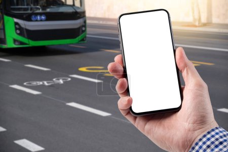 Ein Mann hält ein Smartphone in der Hand. Vorlage für Design. Der Bus fährt mit Markierungen entlang der Straße. Engagierter Bus- und Radweg.