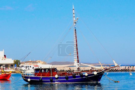Téléchargez les photos : Caique (bateau grec traditionnel) dans le port de Mykonos, île célèbre et magnifique des Cyclades au cœur de la mer Égée - en image libre de droit