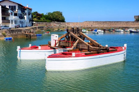 Téléchargez les photos : En Urrugne, dans le port de Socoa, au Pays Basque, ce curieux bateau est utilisé pour transporter d'énormes blocs de pierre utilisés pour construire ou entretenir les digues qui protègent la baie de Saint-Jean-de-Luz - en image libre de droit