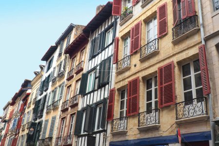 Photo for In Bayonne, in the Basque country, traditional buildings with balcony windows equipped with multicolored shutters and sometimes embellished with wooden half-timbering - Royalty Free Image