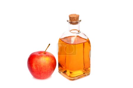 Vinagre de manzana natural. Sobre un fondo blanco aislado. En una botella pequeña y una manzana.
