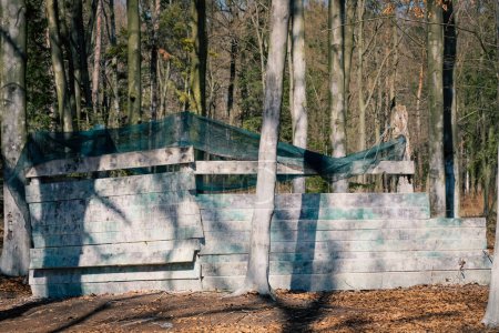 Foto de Shelter behind a wooden wall - a bunker in the paintball arena, a hideout and a field for shooting colored paint balls - Imagen libre de derechos