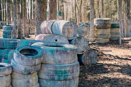 Walls of tires in the woods, paintball arena
