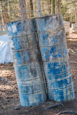 Foto de Barriles de metal en el bosque durante el juego, cubierta y refugio en los deportes en el campo de paintball, paintballs cubierta en la arena - Imagen libre de derechos