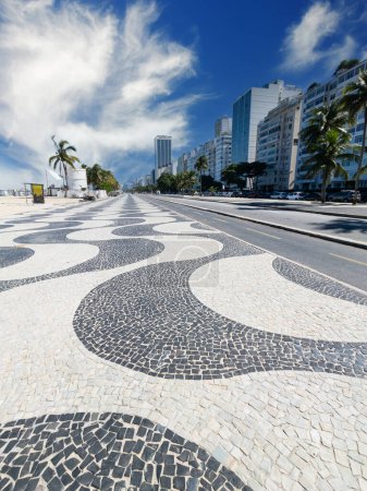 Téléchargez les photos : Célèbre promenade sur la plage de Copacabana et cocotiers avec ciel bleu à Rio de Janeiro Brésil. - en image libre de droit
