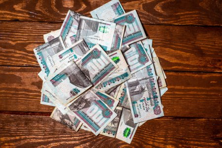 Téléchargez les photos : Egyptian money on a wooden background in denominations of 100 pounds - en image libre de droit