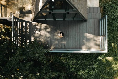 Téléchargez les photos : Une femme se repose et médite dans une maison dans la forêt en automne. Concept de retraite et de méditation - en image libre de droit