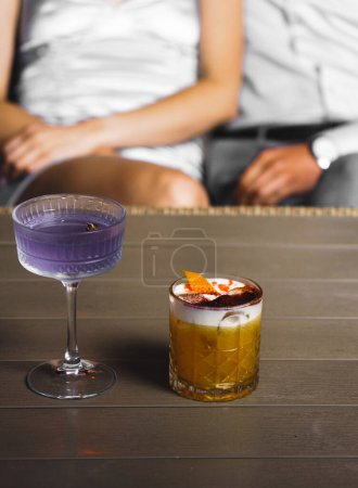 Téléchargez les photos : Un couple amoureux boit un cocktail et fume un narguilé sur la terrasse la nuit. Concept de vie nocturne - en image libre de droit