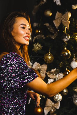 Téléchargez les photos : Une jolie femme pose avec une coupe de champagne près du sapin de Noël. Le concept du Nouvel An et des vacances de Noël - en image libre de droit