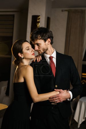 Téléchargez les photos : Un homme et une femme élégants en tenue de soirée, un costume et une robe, posant sur fond d'hôtel luxueux. Concept de casino - en image libre de droit