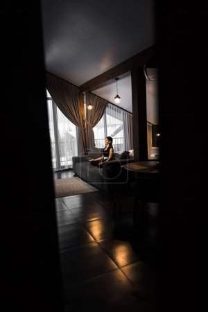 Téléchargez les photos : Femme sportive faisant de la méditation à la maison dans un appartement confortable. Yoga et concept de méditation. Fitness à domicile - en image libre de droit