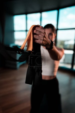 Photo for Beautiful woman doing exercise with trx system.Fitness exercises with loops.Concept workout healthy lifestyle sport. - Royalty Free Image
