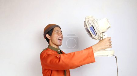 asiático musulmán hombre gesto celebración ventilador en blanco fondo