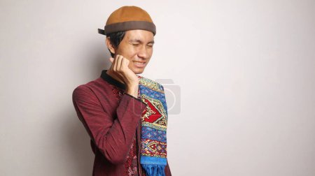 Asiatischer muslimischer Mann gestikuliert mit Zahnschmerzen auf weißem Hintergrund