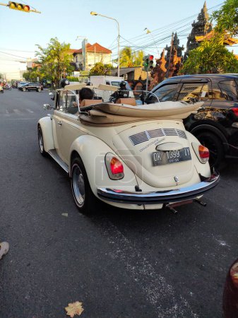 Téléchargez les photos : Classic volkswagen beetle convertible car, stopped at traffic light. Bali - Indonesia ; December 20, 2022. - en image libre de droit