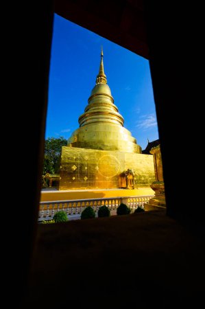 Photo for Ancient golden pagoda in window frame at Wat Phra Singh temple, Chiang Mai province. - Royalty Free Image