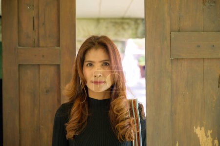 Foto de Thai woman with Wooden Door, Nan Province. - Imagen libre de derechos