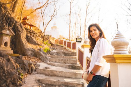 Téléchargez les photos : Asian woman with white pagoda background at Tham Phra Sabai temple, Lampang province. - en image libre de droit