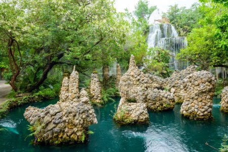 Kleiner Wasserfall und grüner Teich im schattigen Garten, Provinz Chiang Mai.