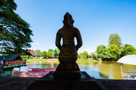 Téléchargez les photos : CHIANG MAI, THAÏLANDE - 2 mai 2020 : Ancienne statue avec vue sur la rivière au temple Chai Mongkon, province de Chiang Mai. - en image libre de droit