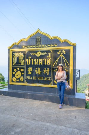Foto de A female tourist with village signage at Pha Hi village, Chiang Rai Province. - Imagen libre de derechos