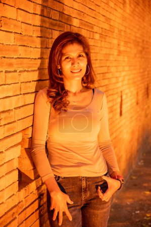 Thailänderin mit alter Backsteinmauer am Abend, Chiang Mai.