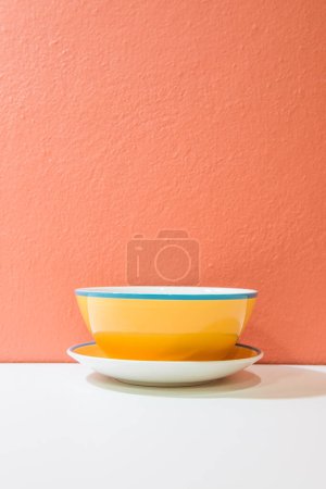 Yellow bowl with orange wall and white floor, Thailand.