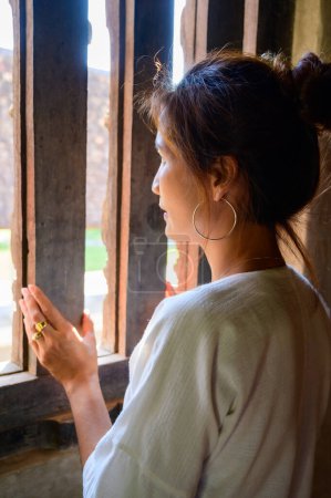 Femme thaïlandaise en robe autochtone thaïlandaise à côté de la fenêtre, Chiang Mai.