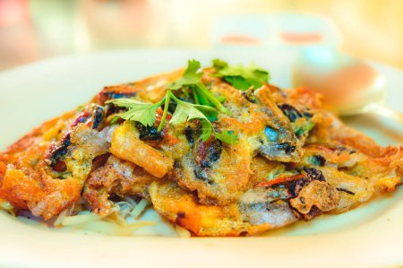 Hoi Tod, Pan fired crispy mussel or crispy fried mussel pancake with egg. This type of food is a street food that Thai people like to eat.