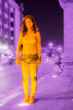Asian traveller woman with Chiang Mai city background at night, Thailand.