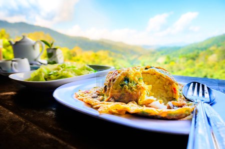 Thai traditional minced pork omelette with rice amidst the refreshing mountain atmosphere, Thailand.