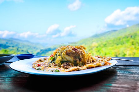 Thai traditional minced pork omelette with rice and stir fried cabbage with fish sauce amidst the refreshing mountain atmosphere, Thailand.
